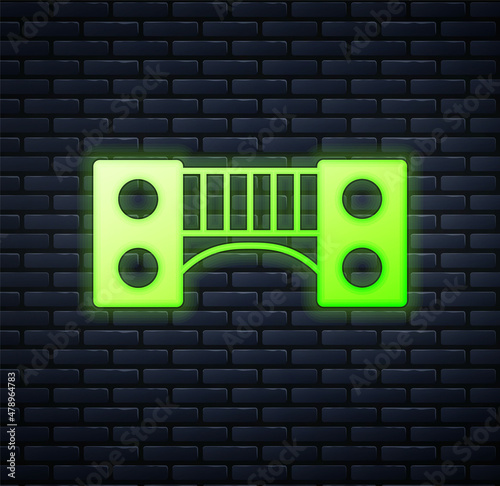 Glowing neon Playground kids bridge icon isolated on brick wall background. Vector