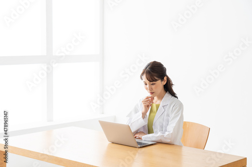 パソコンを使う若い女性の医者 © polkadot