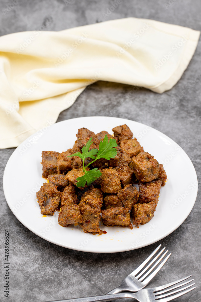 Fried liver cubes on a dark background. Turkish Traditional Food Arnavut Cigeri. Vertical view. Close up Fried liver cubes on a dark background. Turkish Traditional Food Arnavut Cigeri. Vertical view. Close up