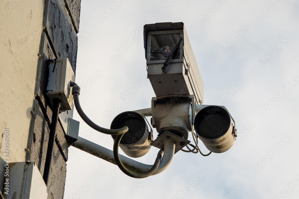 Tough CCTV video camera in a hard case attached to a wall. Security industry. Tough CCTV video camera in a hard case attached to a wall. Security industry.