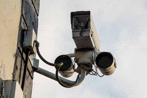 Tough CCTV video camera in a hard case attached to a wall. Security industry.