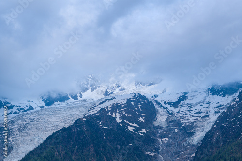 The Bossons glaciers and the Taconnaz glacier hidden by the clouds in the Mont Blanc massif in Europe  in France  in the Alps  towards Chamonix  in summer.