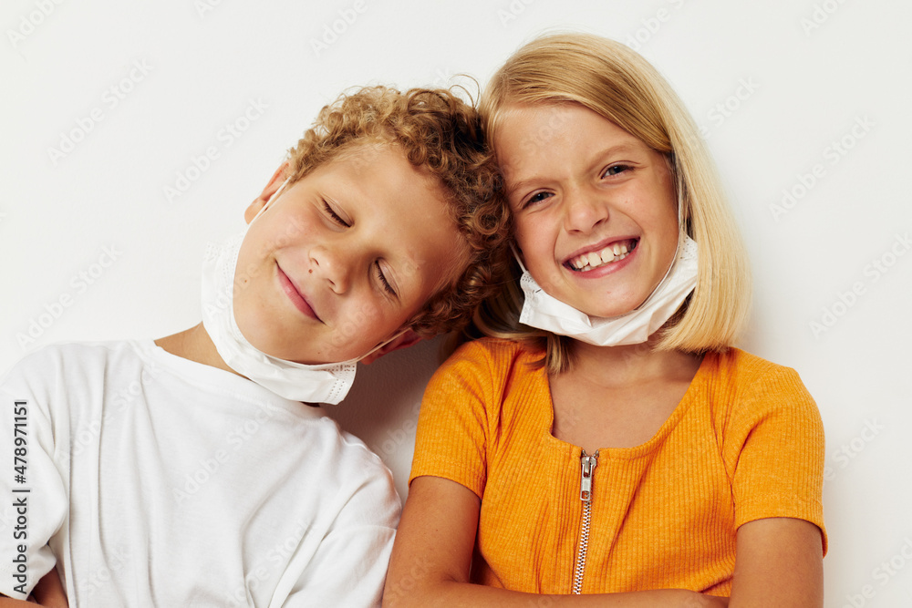 Boy and girl in a medical mask fun isolated background unaltered Boy and girl in a medical mask fun isolated background unaltered