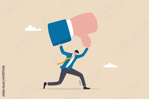 Customer complaint or bad reputation, disappointment from mistake or failure, underperform, negative and dissatisfaction concept, tried businessman carry heavy thumb down symbol on his shoulder. photo
