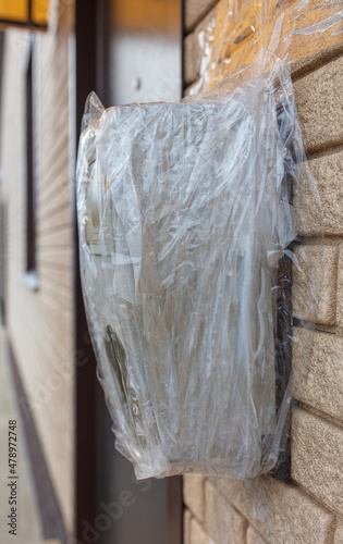 Broken electric meter wrapped in duct tape on the wall © schankz