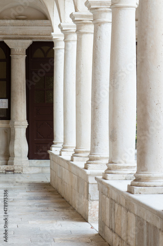 White stone colonnades in the cloister of St Francis church and Franciscan monas Fotobehang
