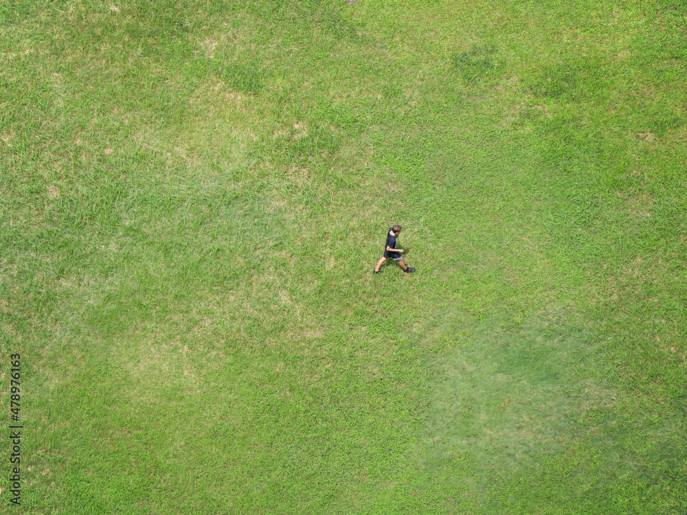 Boy walking through a grassy field Boy walking through a grassy field