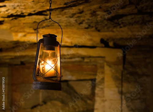 Old vintage candle lamp lantern ganging in Odessa catacombs cave. A photo with free empty copy space for text