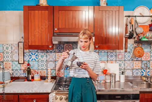 Attractive woman pouring percolated coffee in a kitchen