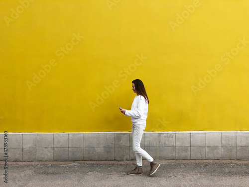 person walking on the street and using mobile phone