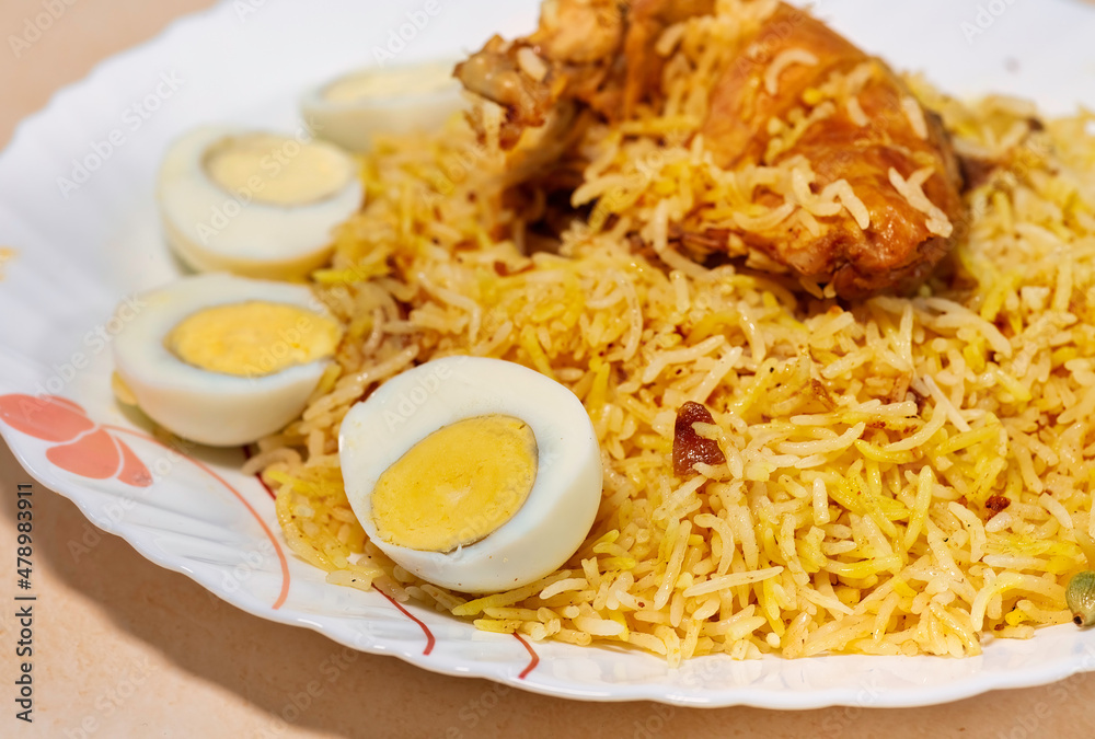Spicy Indian chicken biryani rice with chicken leg and sliced eggs in closeup macro view Spicy Indian chicken biryani rice with chicken leg and sliced eggs in closeup macro view