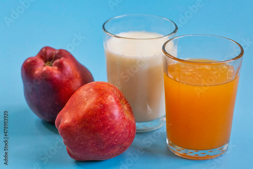 Healthy food with apples, fruit juice and a glass of milk in closeup on blue background 