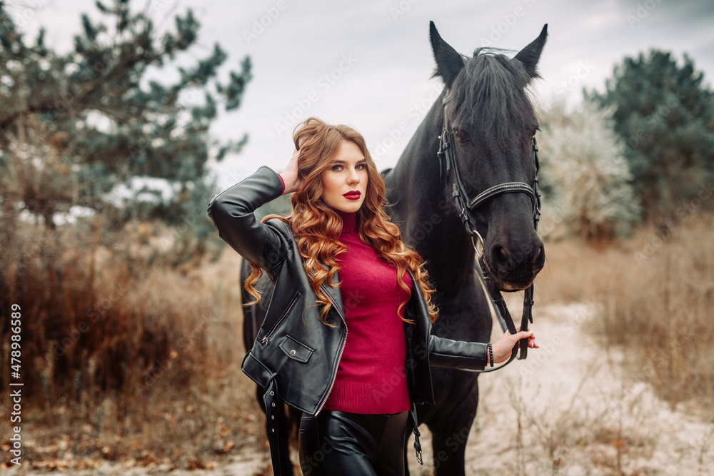 Obraz premium Beautiful young woman posing with a horse outdoors, close up