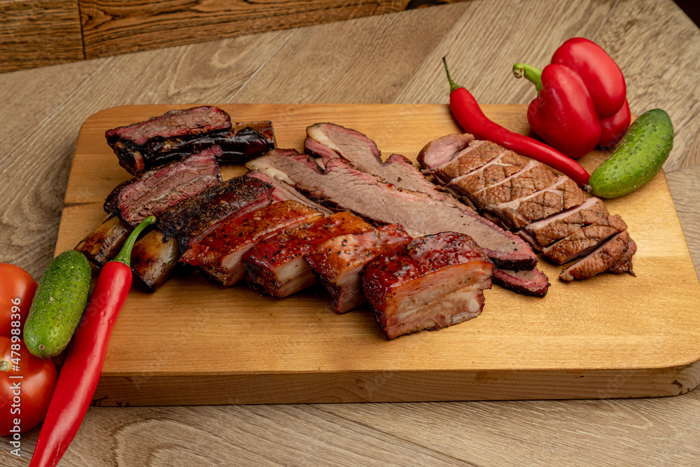 assorted smoked meats served on a wooden tray assorted smoked meats served on a wooden tray