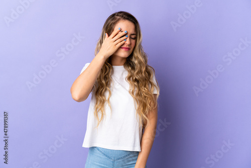 Young Brazilian woman isolated on purple background with headache