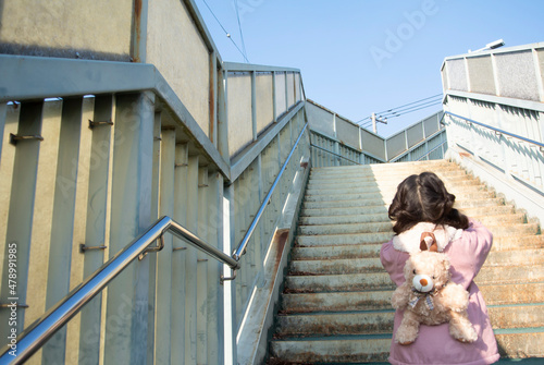 歩道橋で階段を登る女の子の後ろ姿