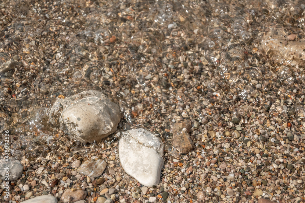Underwater grey stones background at sea beach. Blurry wet pebble texture on sunny day. Underwater grey stones background at sea beach. Blurry wet pebble texture on sunny day.