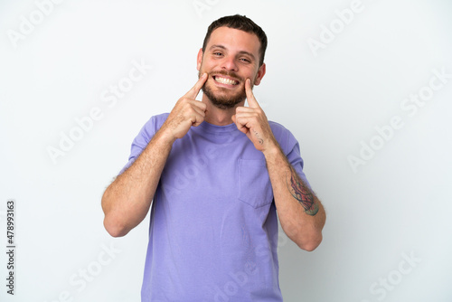 Young Brazilian man isolated on white background smiling with a happy and pleasant expression