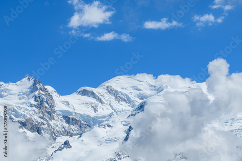 White clouds over Mont Blanc in the Mont Blanc Massif in Europe, France, the Alps, towards Chamonix, in summer on a sunny day.