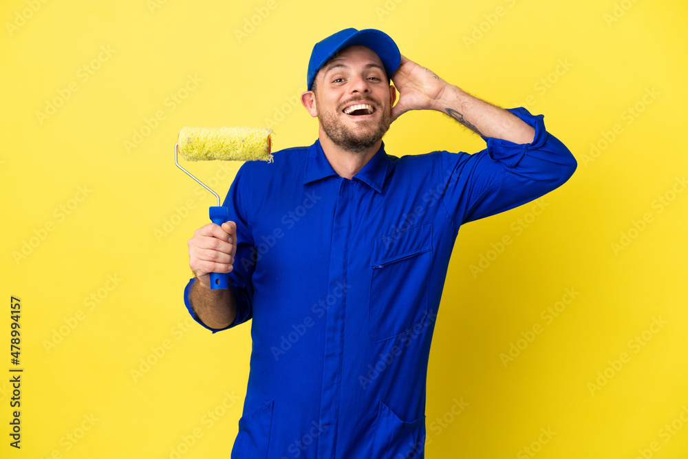 Painter Brazilian man isolated on yellow background with surprise expression