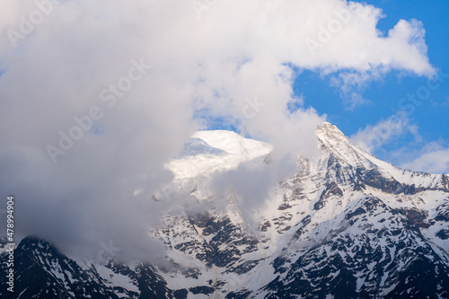 Mont Blanc and the Aiguille du Gouter hidden by clouds at sunset in Europe, France, the Alps, towards Chamonix, in summer, on a sunny day.