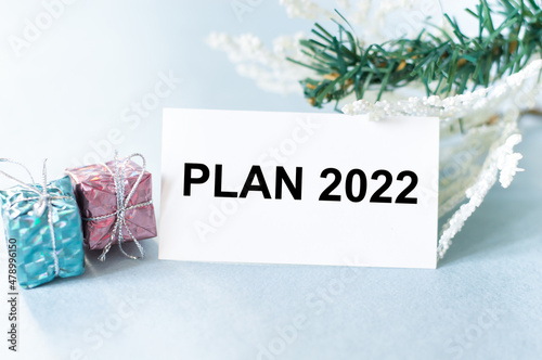 2022 plan text on card on a festive background next to two gifts in a package