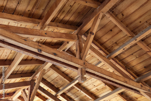 Roof overlap. Roof structure from the inside. Wooden beams, rafters and joists.  photo