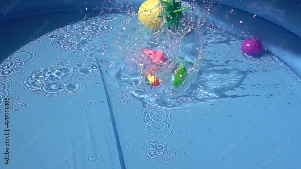 Toys falling and floating in a pool.