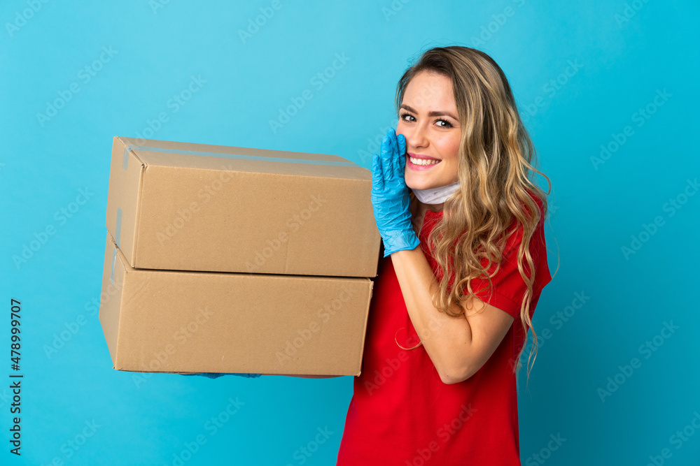 Young delivery woman isolated on white background whispering something
