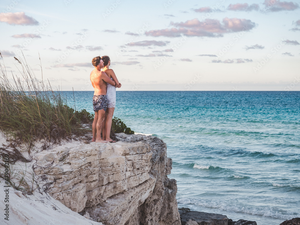 Handsome man and pretty woman stand against the backdrop of a rock and look into the distance. Outdoors, closeup. Concept of leisure and travel