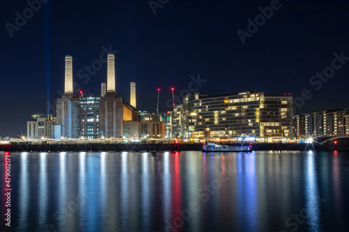 The newly renovated Battersea Power Station and apartments, night shot, reflected in River Thames, Nine Elms, Wandsworth, London photo