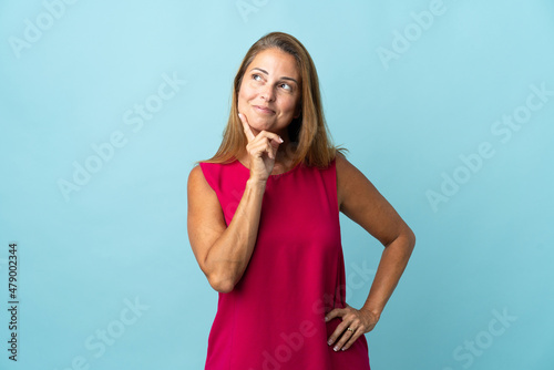 Middle age brazilian woman isolated on blue background thinking an idea while looking up