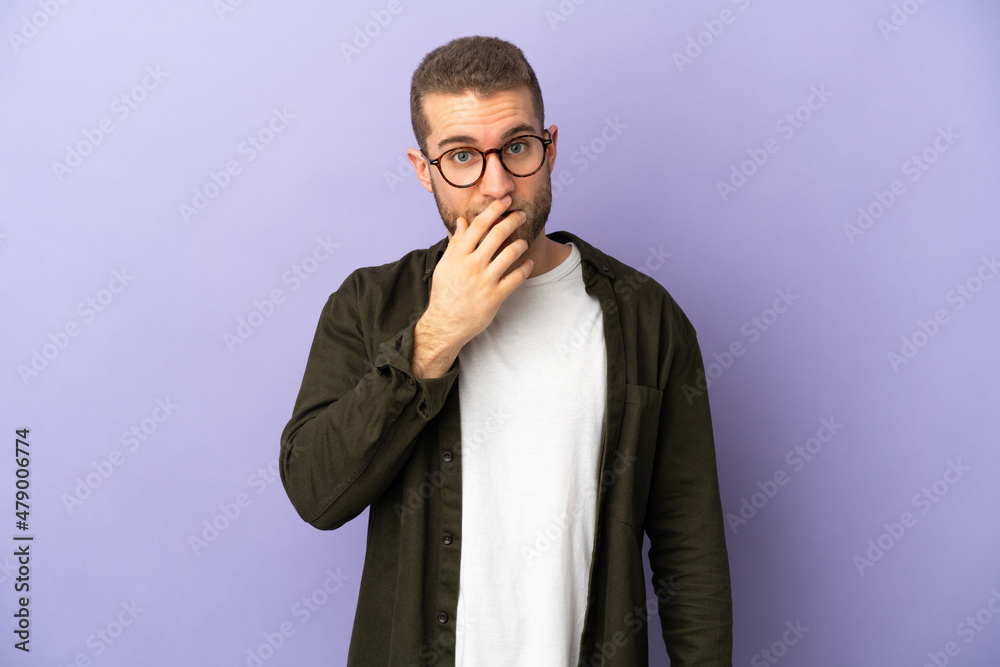Young handsome caucasian man isolated on purple background surprised and shocked while looking right Young handsome caucasian man isolated on purple background surprised and shocked while looking right