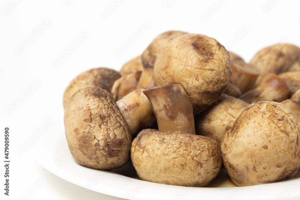 Boiled mushrooms on a white background. Boiled champignons on a white plate. Healthy diet Boiled mushrooms on a white background. Boiled champignons on a white plate. Healthy diet