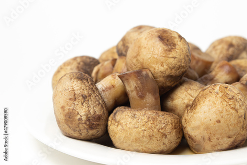 Boiled mushrooms on a white background. Boiled champignons on a white plate. Healthy diet