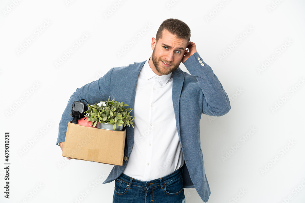 Young caucasian making a move while picking up a box full of things isolated on white background having doubts Young caucasian making a move while picking up a box full of things isolated on white background having doubts