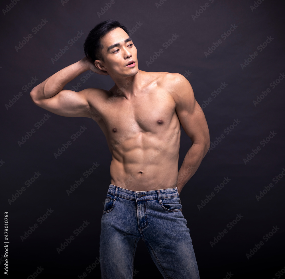 Muscular bodybuilder Asian man doing posing over black background Muscular bodybuilder Asian man doing posing over black background