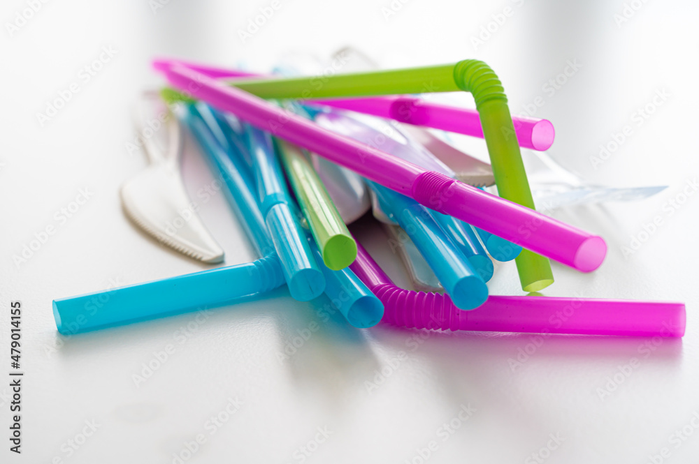 Plates, straws, knives, forks, glasses, disposable plastic objects, photographed closely. Plastic recycling and sales ban. Plates, straws, knives, forks, glasses, disposable plastic objects, photographed closely. Plastic recycling and sales ban.