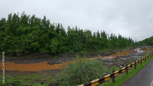 View of the Ambika river flowing in front of the hills during the monsoon as seen from the hill near Gira waterfall at Waghai near Saputara in Gujarat, India photo