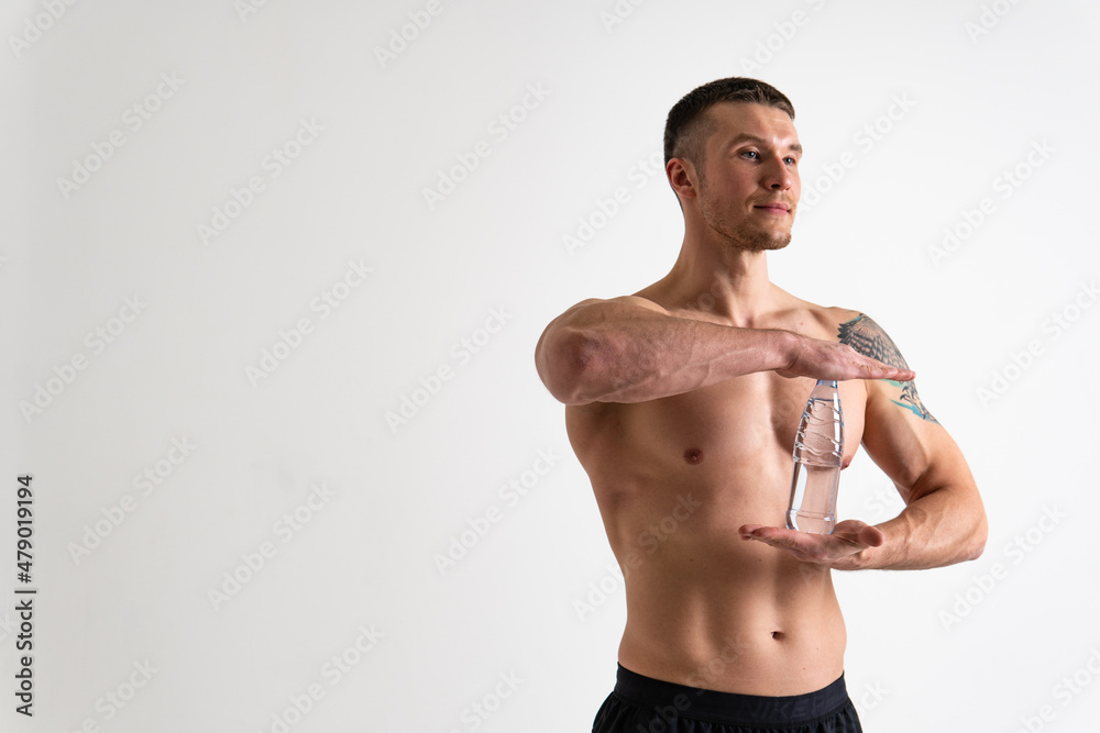 Male drink-water fitness is pumped with a towel on a white background isolated strong muscular training male bottle guy, muscles athletic. Towel copy pace, sportsman one muscle