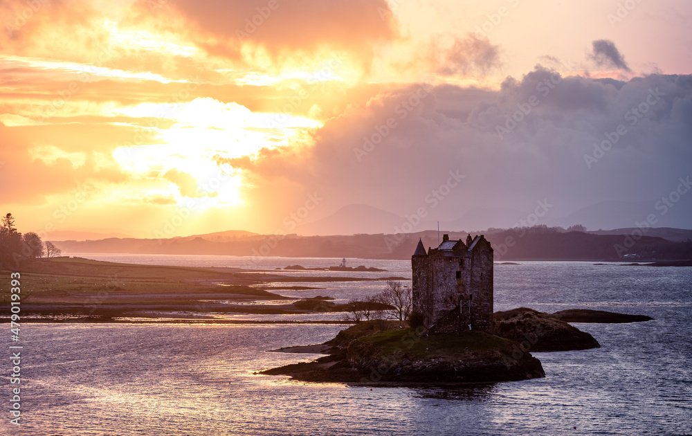 Scottish Castle on Island within a sea loch at sunset with sea sunset view