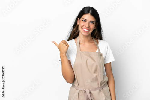 Restaurant waiter over isolated white background pointing to the side to present a product