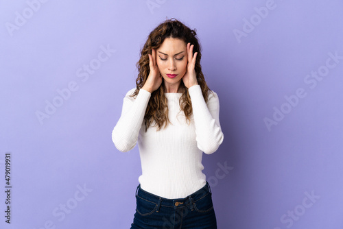 Young caucasian woman isolated on purple background with headache