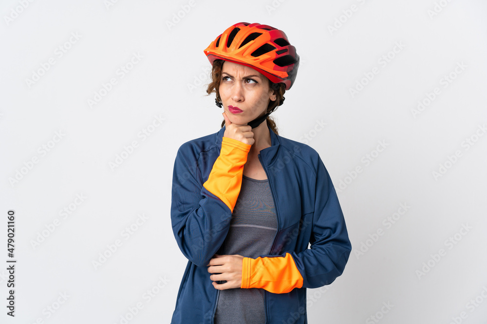 Young cyclist woman isolated on white background having doubts and thinking Young cyclist woman isolated on white background having doubts and thinking