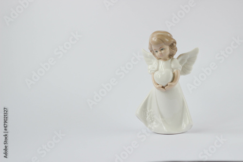 Little angel holding a heart on a white background.Back space