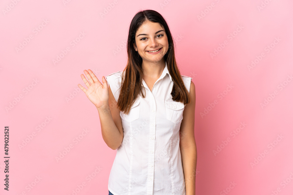 Young caucasian woman isolated on pink background saluting with hand with happy expression Young caucasian woman isolated on pink background saluting with hand with happy expression