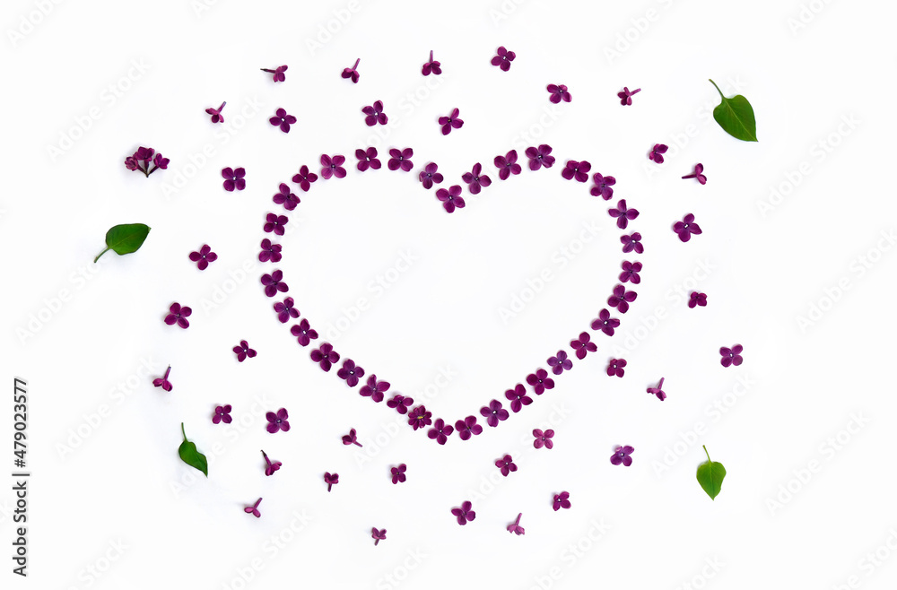 Lilac flowers frame in a shape of a heart on a white background with space for text. Top view, flat lay