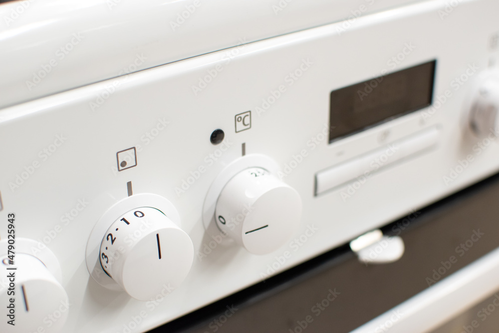 Close-up shot of a white cooker's front panel Close-up shot of a white cooker's front panel