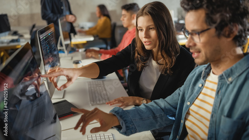 Diverse Multiethnic Group of Female and Male Students Sitting in College Room, Collaborating on School Projects on a Computer. Young Scholars Study, Talk, Apply Academic Skills and Knowledge in Class.