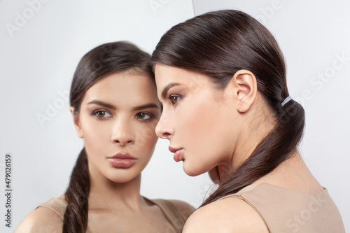 Closeup upset young woman with worried stressed face expression and mirror. Stress, obsessive compulsive, adhd, anxiety, ocd disorders